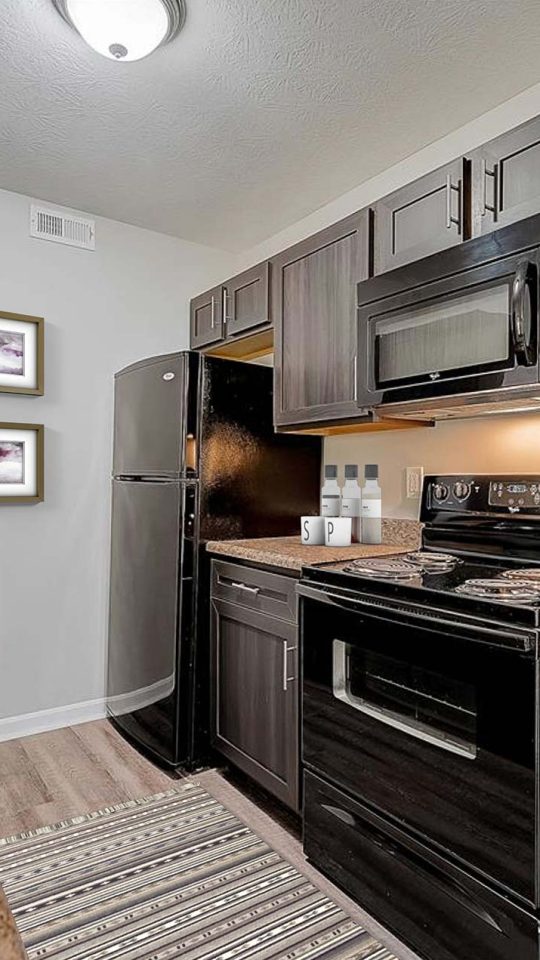 kitchen with black appliances and granite counter tops at The Worthington Green